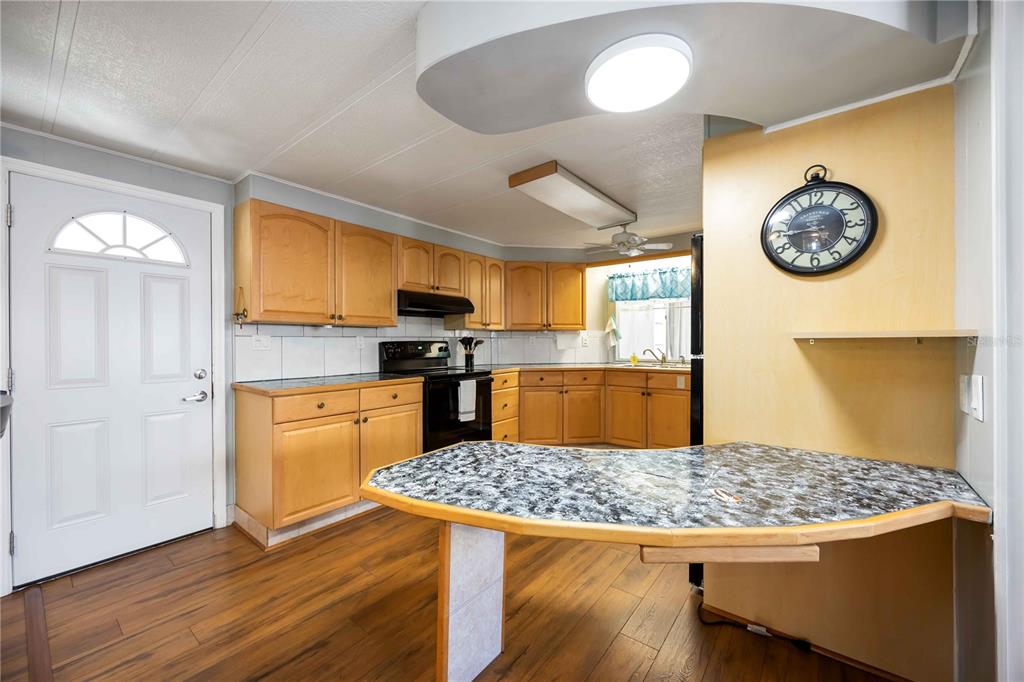 10303 Burnt Store Road, Unit 169 Punta Gorda, FL 33950 - Photo 5 of 34 a kitchen with kitchen island granite countertop wooden floors and stainless steel appliances