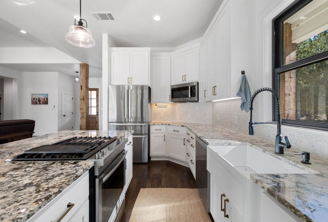 340 Mark Young Road Smithville, TX 78957 - Photo 14 of 40 a kitchen with stainless steel appliances granite countertop a sink stove and refrigerator