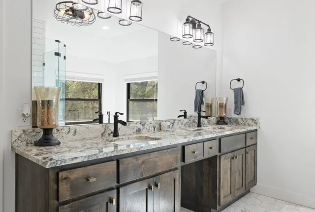 a bathroom with a granite countertop sink and a mirror
