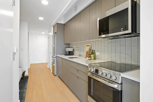 a kitchen with a sink a stove and cabinets