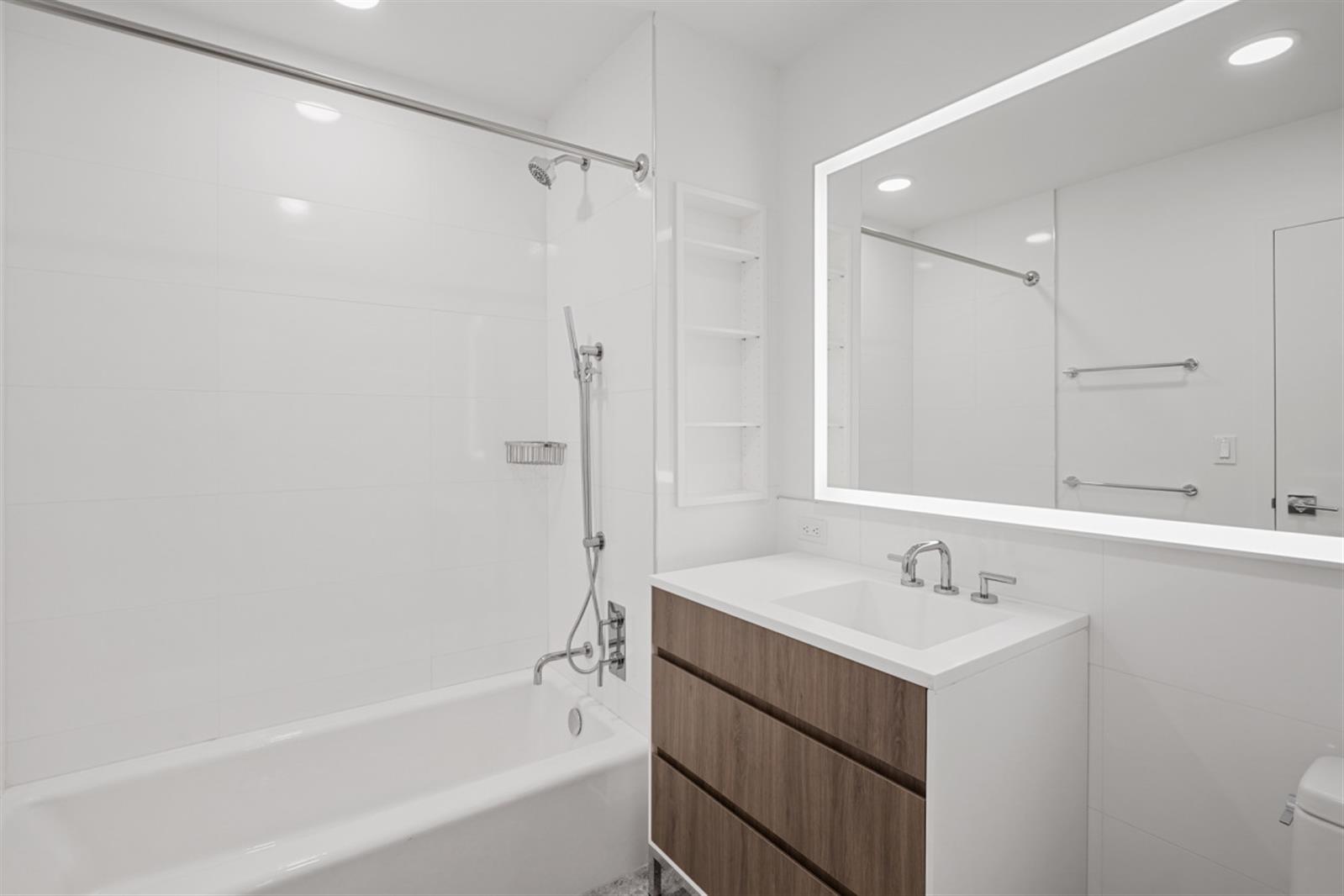 18 6th Avenue, Unit 711 Brooklyn, NY 11217 - Photo 27 of 35 a bathroom with a shower sink vanity and mirror