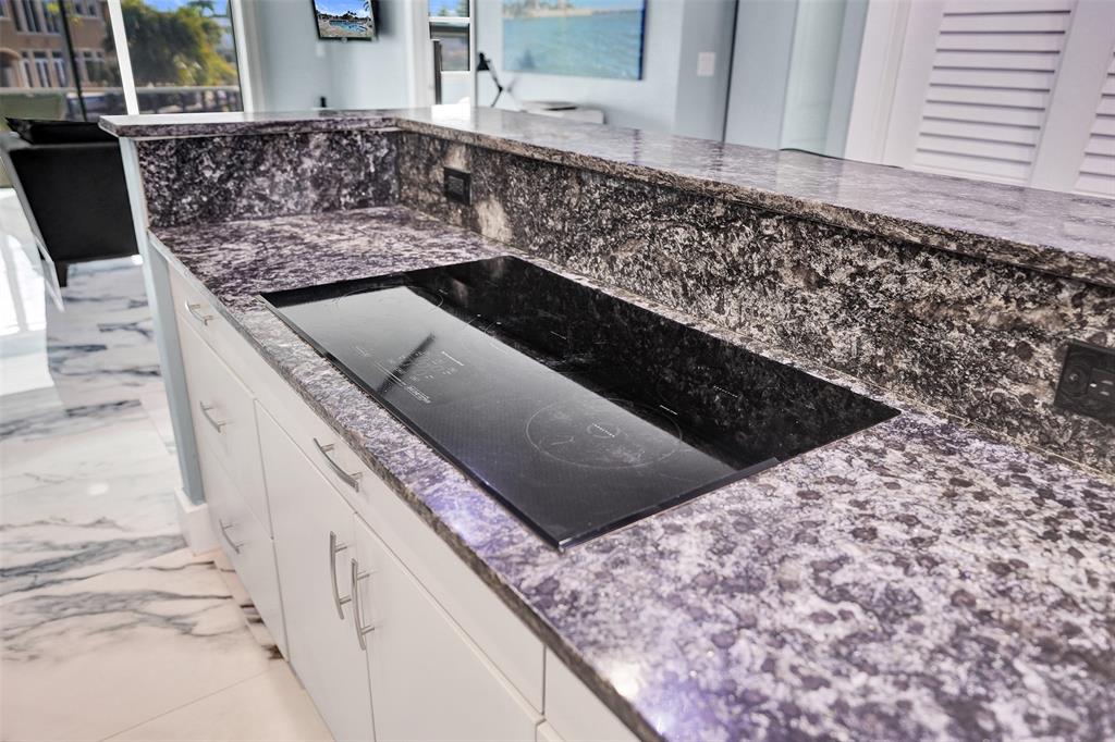 2330 Northeast 36th Street, Unit 9 Lighthouse Point, FL 33064 - Photo 18 of 48 a kitchen with a stove top oven and cabinets