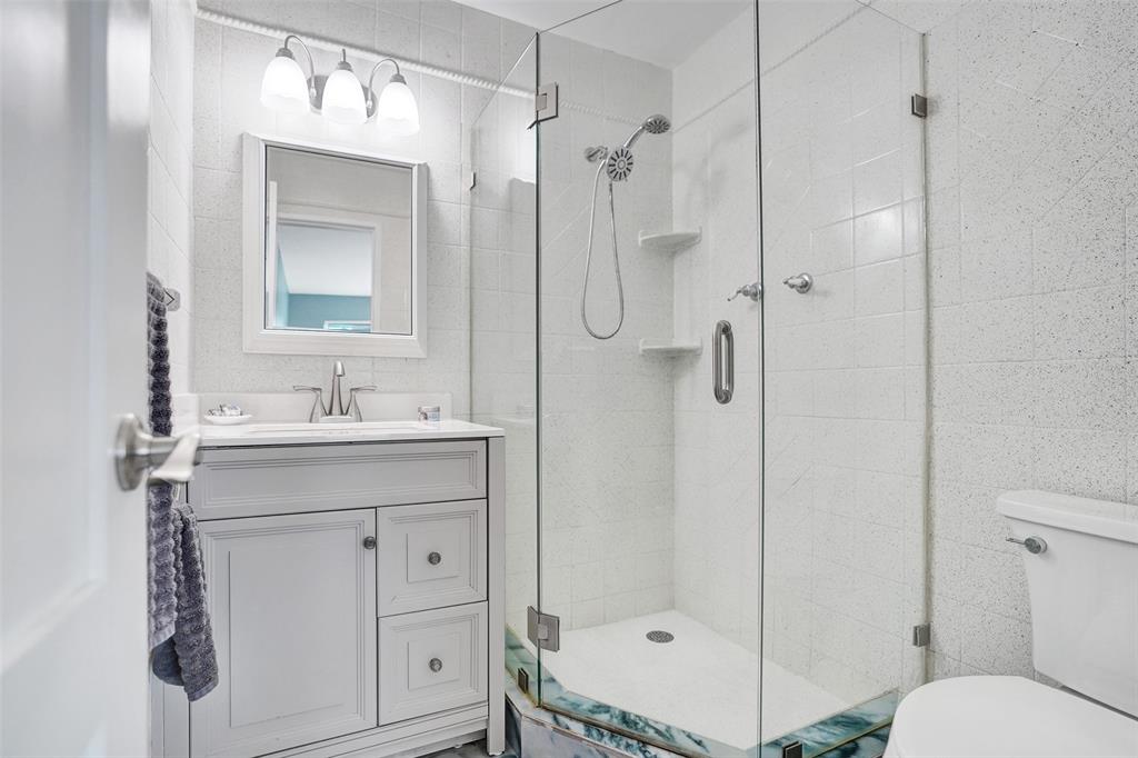 2330 Northeast 36th Street, Unit 9 Lighthouse Point, FL 33064 - Photo 34 of 48 a bathroom with a sink a toilet and shower