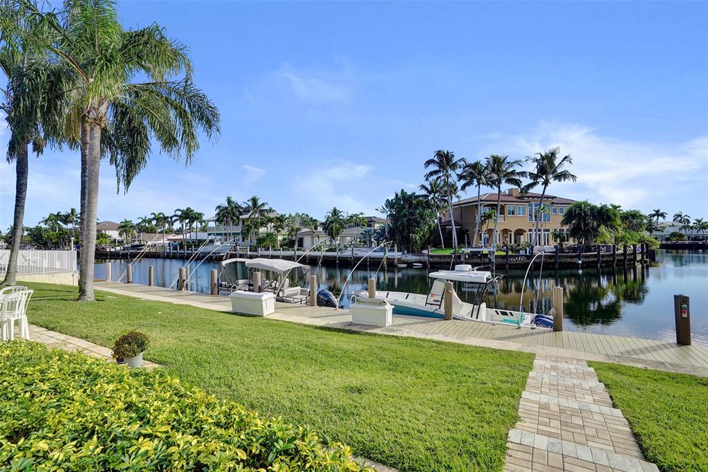 2330 Northeast 36th Street, Unit 9 Lighthouse Point, FL 33064 - Photo 46 of 48 a swimming pool with outdoor seating and a garden