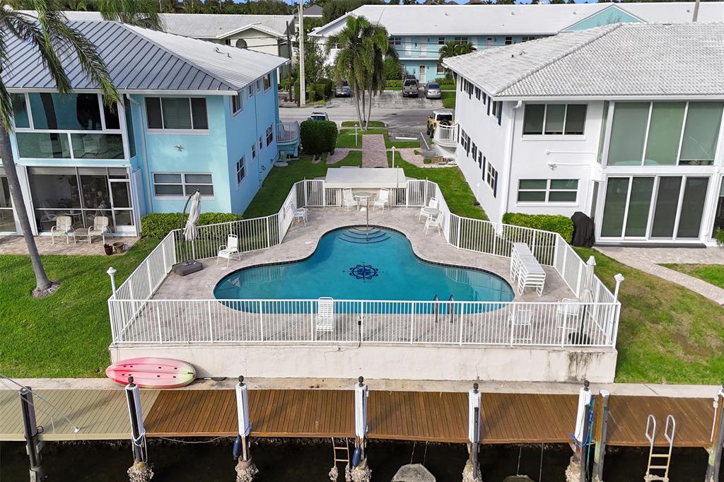 2330 Northeast 36th Street, Unit 9 Lighthouse Point, FL 33064 - Photo 5 of 48 a view of a house with pool and chairs