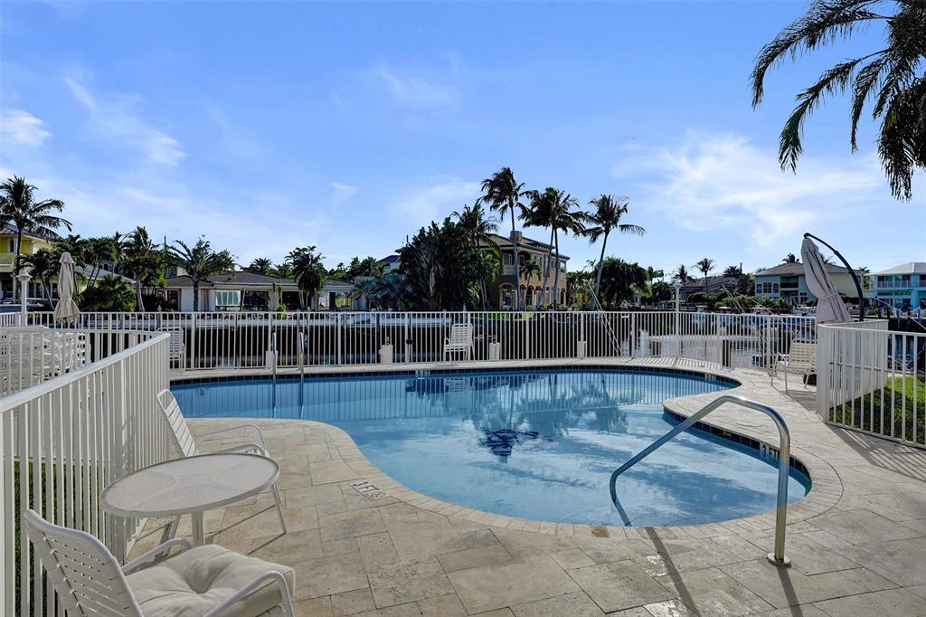 2330 Northeast 36th Street, Unit 9 Lighthouse Point, FL 33064 - Photo 7 of 48 a view of a swimming pool with a lounge chair