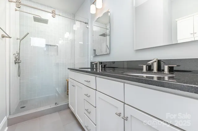 a bathroom with double sink and a shower