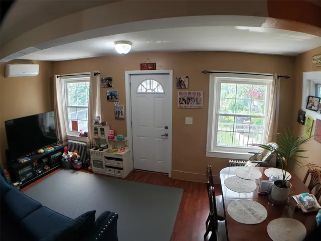 a hallway with wooden floor and potted plant