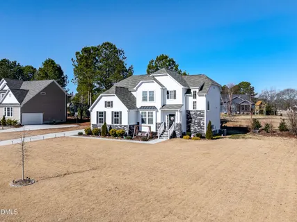 a view of a house with a yard and large trees