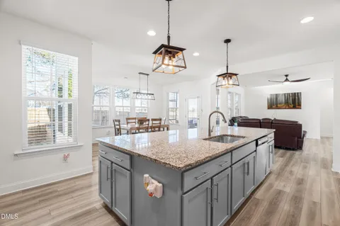 a kitchen with stainless steel appliances granite countertop a sink a stove and a wooden floors