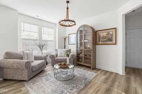 a living room with furniture two window and a dining table
