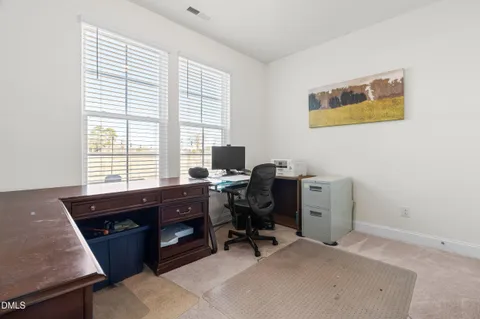 a view of a workspace with furniture and a window