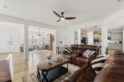 a living room with furniture and a view of kitchen