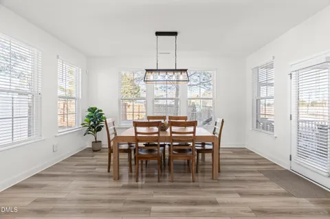 a dining room with furniture a chandelier and wooden floor