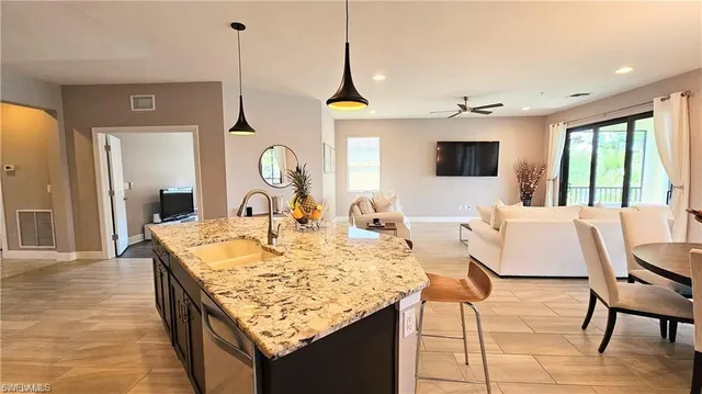 a living room with granite countertop kitchen island furniture and a chandelier