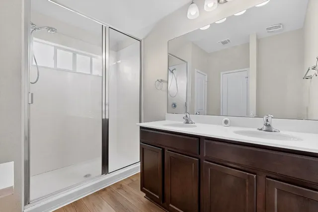 a bathroom with a double vanity sink mirror and shower