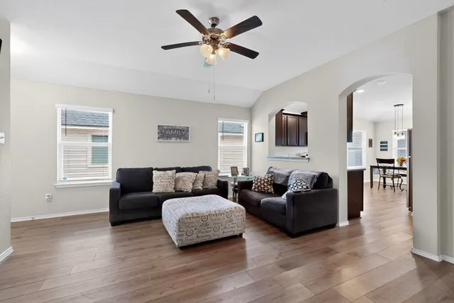 a living room with furniture and a wooden floor