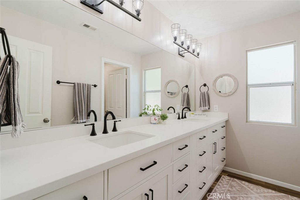 32480 The Old Road Castaic, CA 91384 - Photo 33 of 68 a bathroom with a double vanity sink and a mirror
