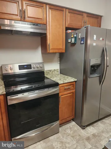a kitchen with stainless steel appliances granite countertop a stove and a refrigerator