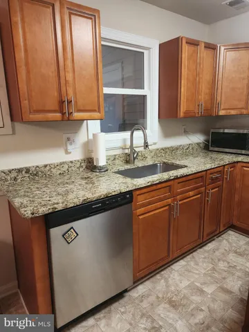 a kitchen with stainless steel appliances granite countertop wooden cabinets a sink and dishwasher