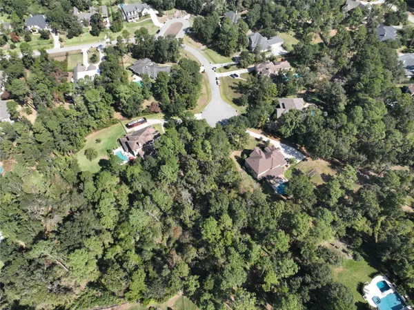 an aerial view of residential houses with outdoor space and trees