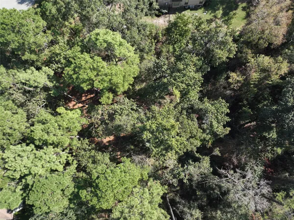 an aerial view of residential house with outdoor space and trees all around