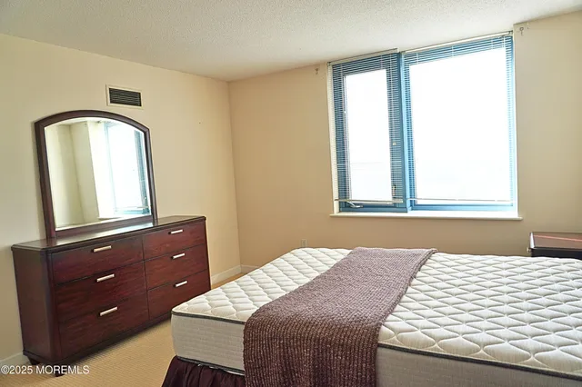 a bedroom with a bed and a dresser with mirror