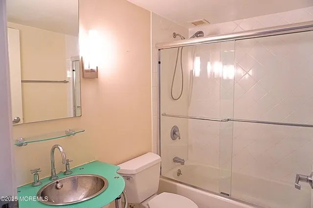 a bathroom with a shower a toilet and a sink