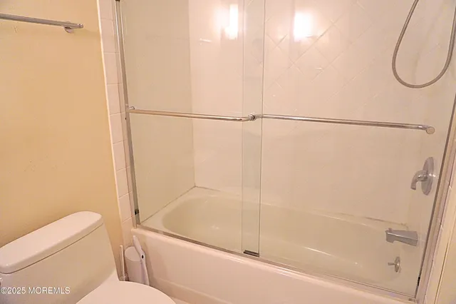 a bathroom with a granite countertop shower and a toilet