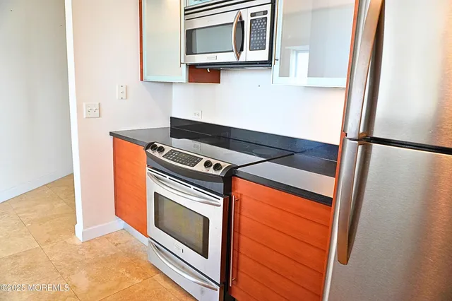 a kitchen with stainless steel appliances granite countertop a stove a microwave and a refrigerator