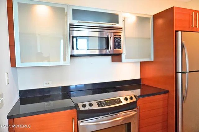 a kitchen with stainless steel appliances granite countertop a stove and a microwave