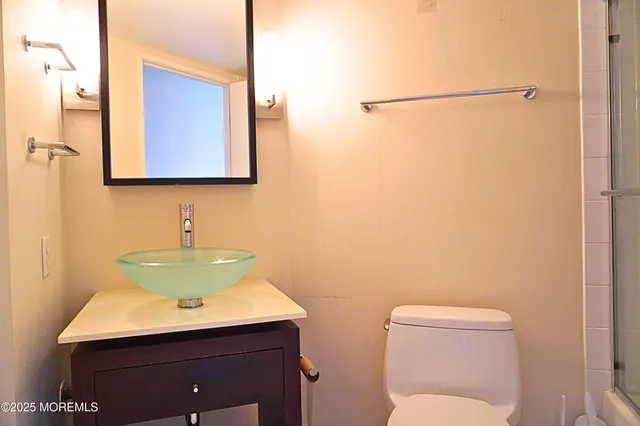 a bathroom with a toilet sink and mirror