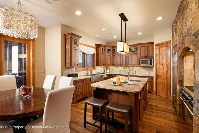 a dining room with furniture a chandelier and wooden floor