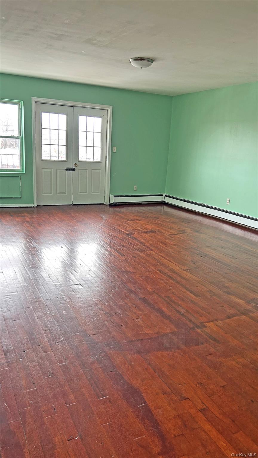 93-26 197th Street, Unit # 3 Queens, NY 11423 - Photo 2 of 14 Spare room with dark wood finished floors and a baseboard radiator