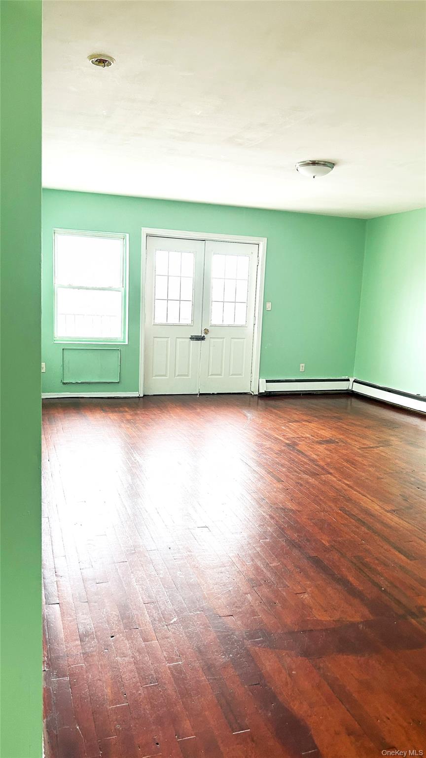 93-26 197th Street, Unit # 3 Queens, NY 11423 - Photo 3 of 14 Spare room featuring plenty of natural light and dark wood finished floors