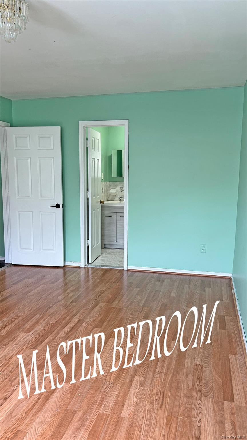 93-26 197th Street, Unit # 3 Queens, NY 11423 - Photo 5 of 14 Unfurnished bedroom with wood finished floors and connected bathroom