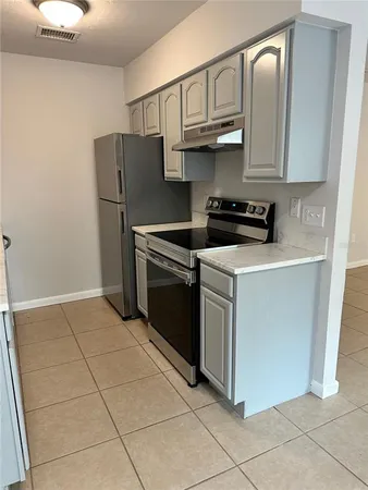 a kitchen with stainless steel appliances granite countertop a stove a refrigerator and a cabinets