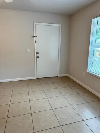 a view of a livingroom with an empty space and a window