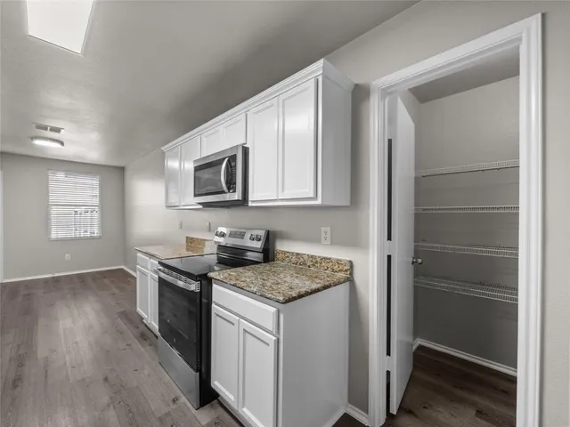 a kitchen with stainless steel appliances granite countertop a stove microwave and refrigerator