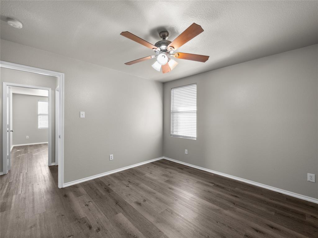 1021 Badger Run Lancaster, TX 75134 - Photo 17 of 25 a view of an empty room with wooden floor and a ceiling fan