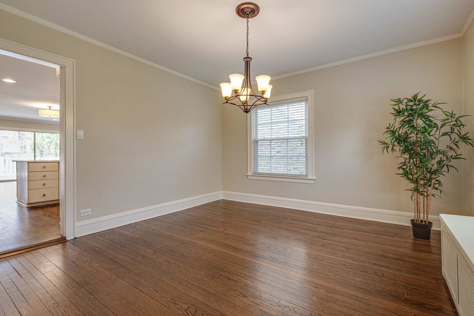 1417 Tower Road Winnetka, IL 60093 - Photo 11 of 39 an empty room with wooden floor chandelier and windows