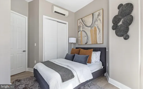 a bedroom with a bed and a painting on the wall