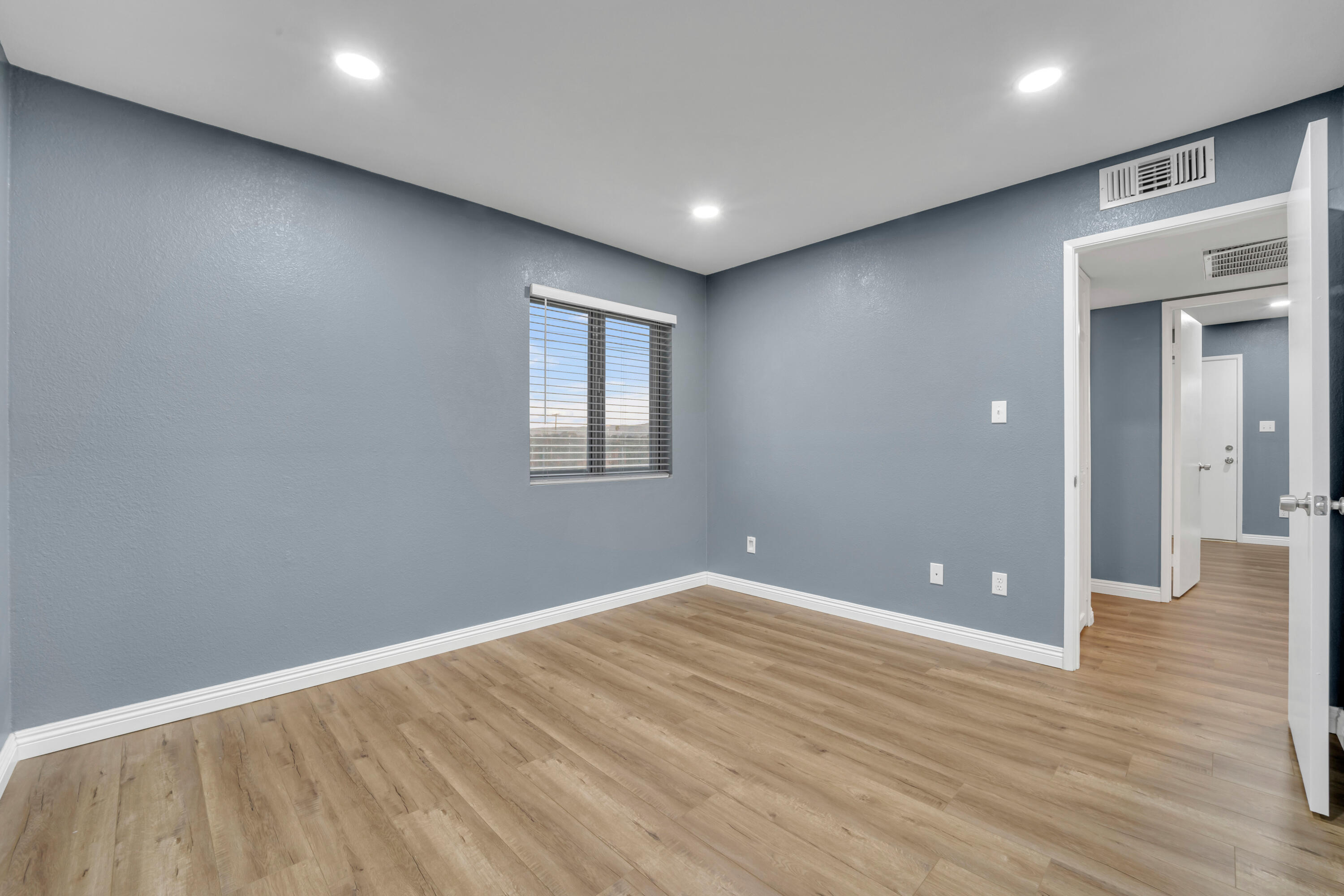 1032 South Farragut Street Ridgecrest, CA 93555 - Photo 13 of 32 an empty room with wooden floor and windows
