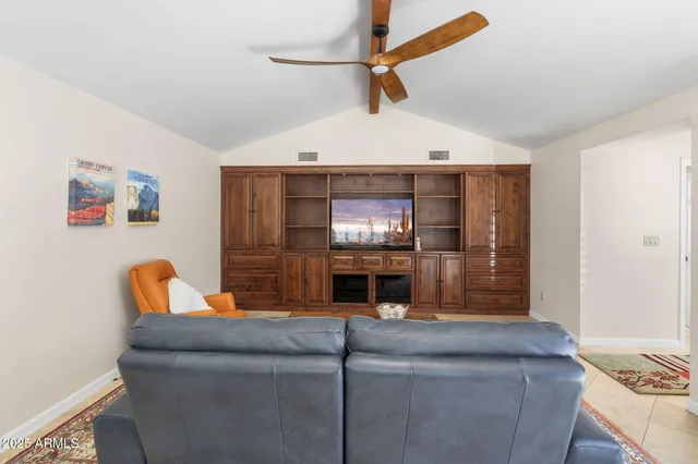 a living room with couches and kitchen view with wooden floor