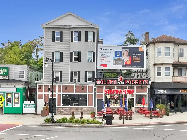 a view of street with large building and cars parked