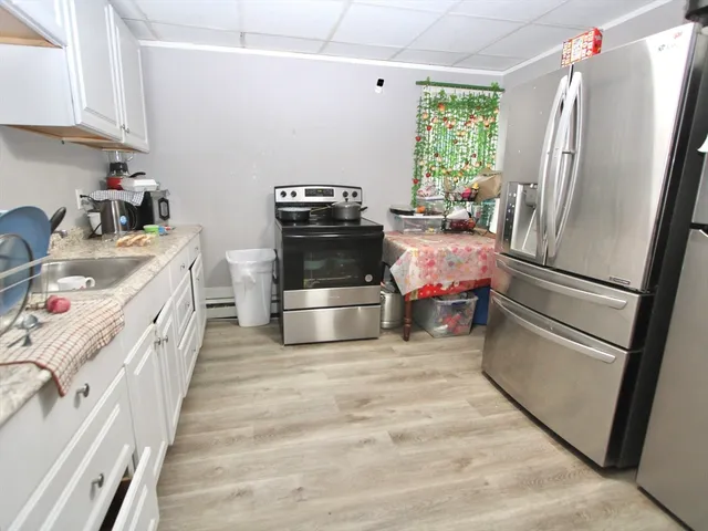 a kitchen with stainless steel appliances a refrigerator sink and wooden floor
