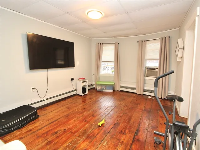 a view of a livingroom with wooden floor and a flat screen tv