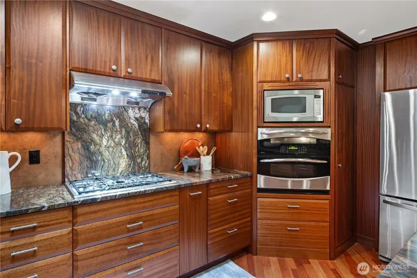a kitchen with granite countertop wooden cabinets and stainless steel appliances