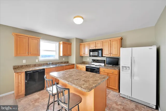 a kitchen with a stove a refrigerator and a stove top oven