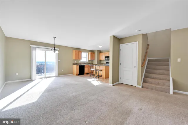 a view of an empty room with a fireplace and a window